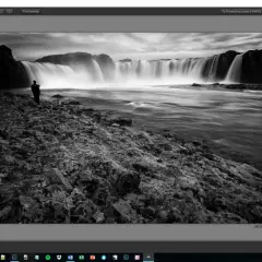 Czarno-biały wodospad z sylwetką fotografa, edytowany w programie z darmowe filtry photoshop.