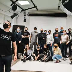 Grupa studentów na zajęciach w szkole fotografii pozuje do wspólnego zdjęcia.