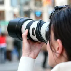 Kobieta z aparatem, gotowa do uchwycenia chwili. Inspiracja dla każdego bloga o fotografii.