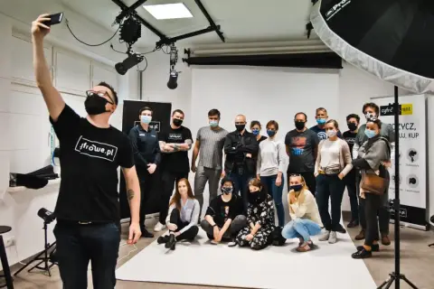 Grupa studentów na zajęciach w szkole fotografii pozuje do wspólnego zdjęcia.
