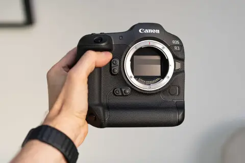 Dłoń trzyma aparat Canon EOS R3. Profesjonalny sprzęt gotowy do akcji.