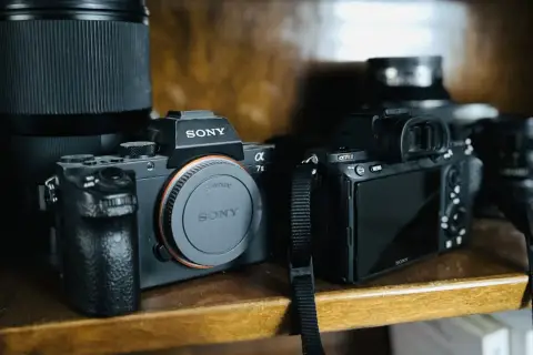 Dwa aparaty Sony: jeden cyfrowy z obiektywem, drugi to lustrzanka z widokiem z tyłu.