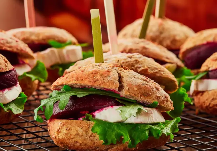 Mini burgery z burakiem, serem kozim i rukolą. Apetyczna fotografia kulinarna.