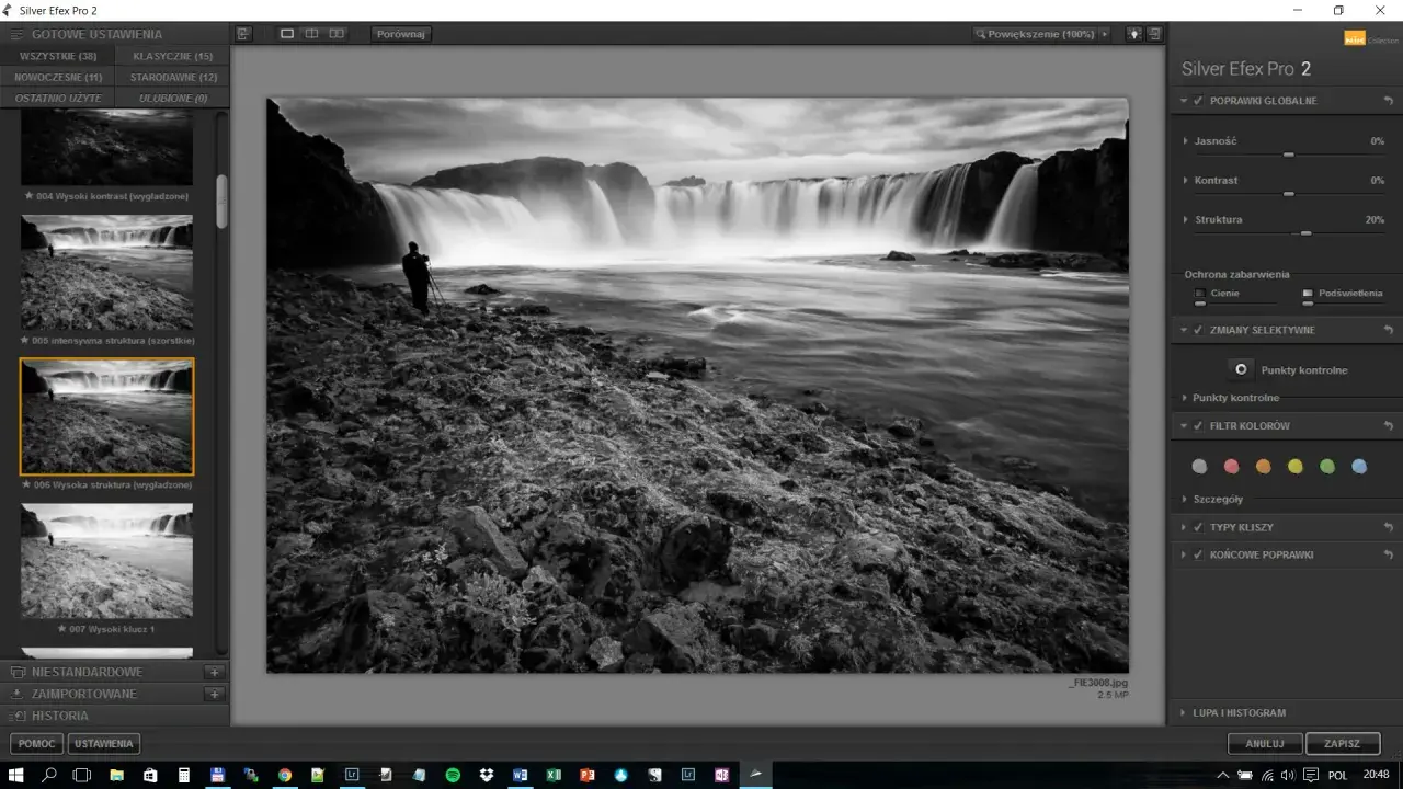 Czarno-biały wodospad z sylwetką fotografa, edytowany w programie z darmowe filtry photoshop.