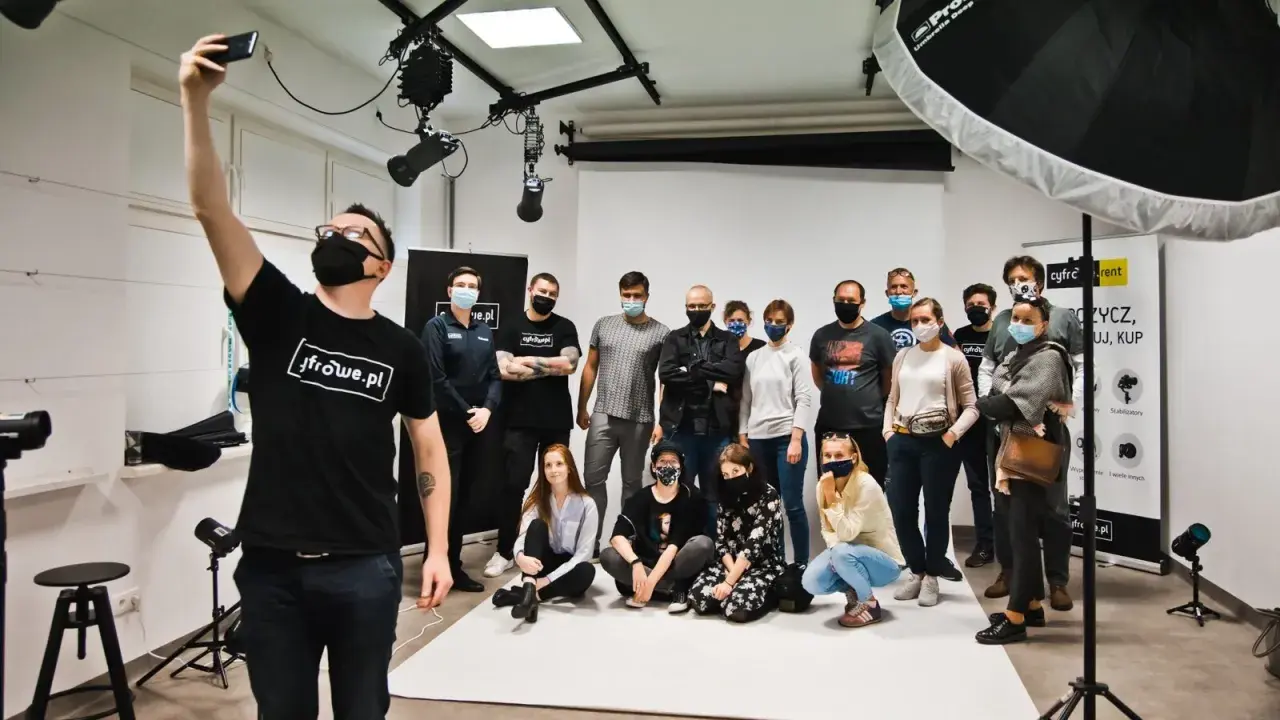 Grupa studentów na zajęciach w szkole fotografii pozuje do wspólnego zdjęcia.