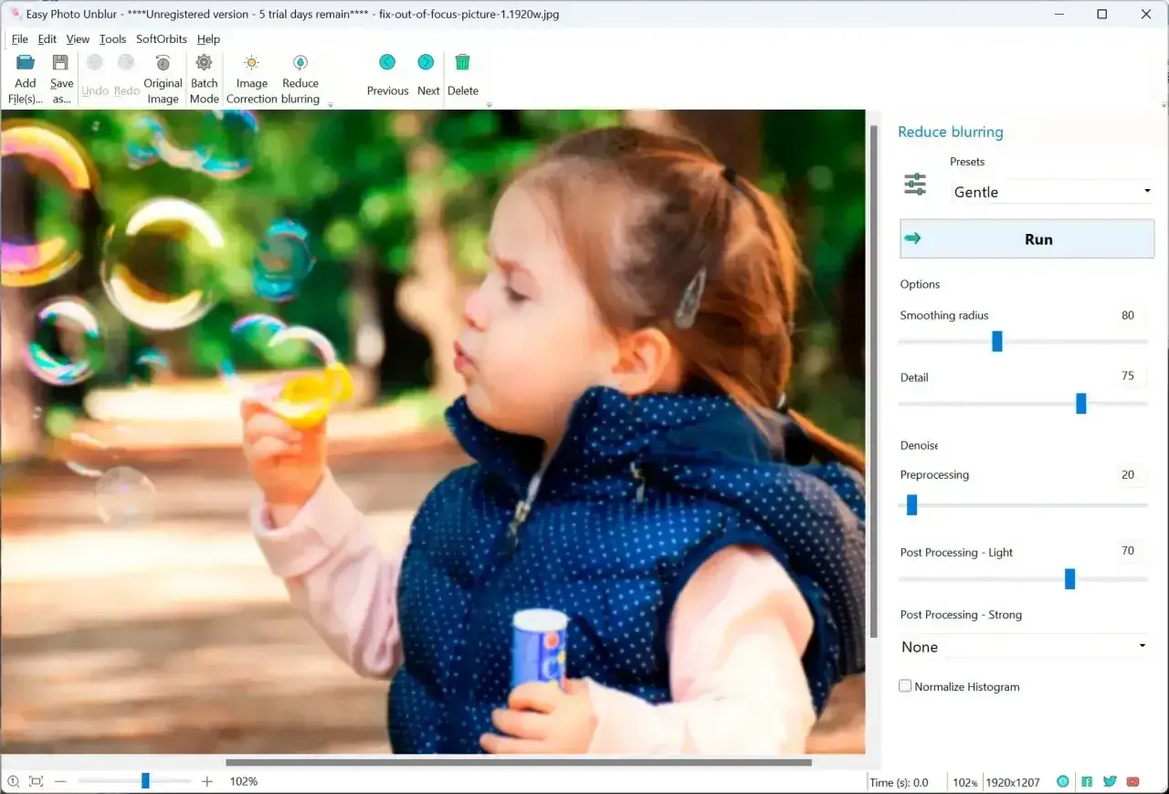 Dziewczynka dmucha bańki, a program Easy Photo Unblur pokazuje, jak wyostrzyć zdjęcie, regulując suwaki.