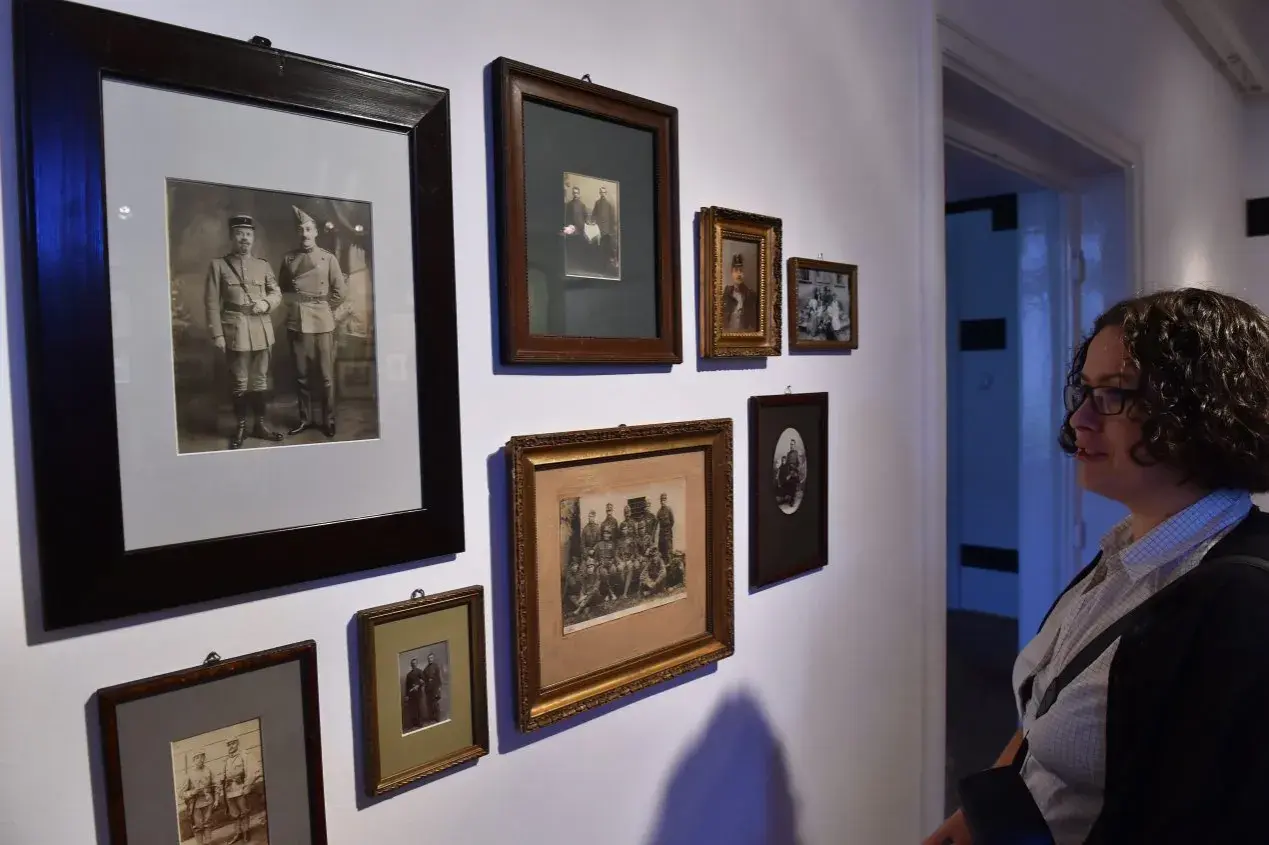 Kobieta ogląda galerię starych fotografii. Czy robienie komuś zdjęć jest karalne? W tym przypadku to historia uwieczniona na papierze.
